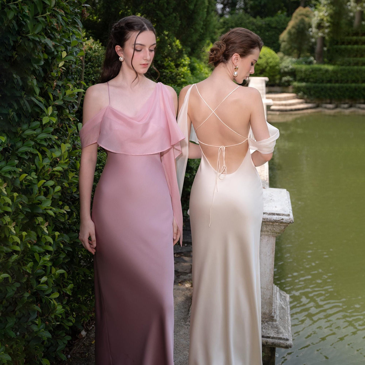 May include: Two elegant floor-length gowns. One is a dusty rose color with a draped shoulder detail. The other is a cream color with a low back and delicate strap design. Both dresses are made of a silky material and are suitable for formal events.