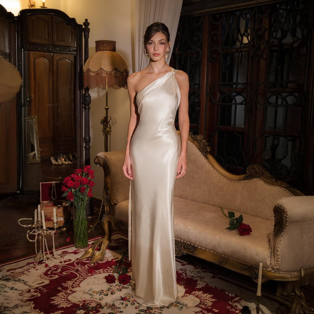 May include: A floor-length, champagne-colored satin gown featuring a single-shoulder neckline and a sleek, form-fitting silhouette. The fabric has a smooth, reflective finish that drapes down to the floor, creating a clean and elegant appearance.