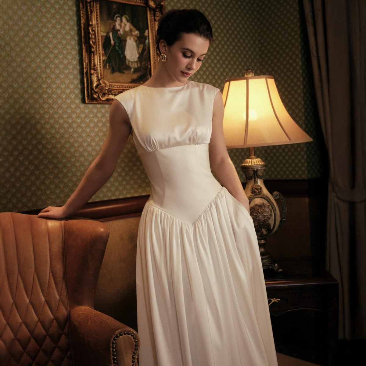 May include: A white satin dress with a fitted bodice and a flowing skirt. The dress has a scoop neckline and a V-shaped waistline. The dress is sleeveless and appears to be vintage or retro style.