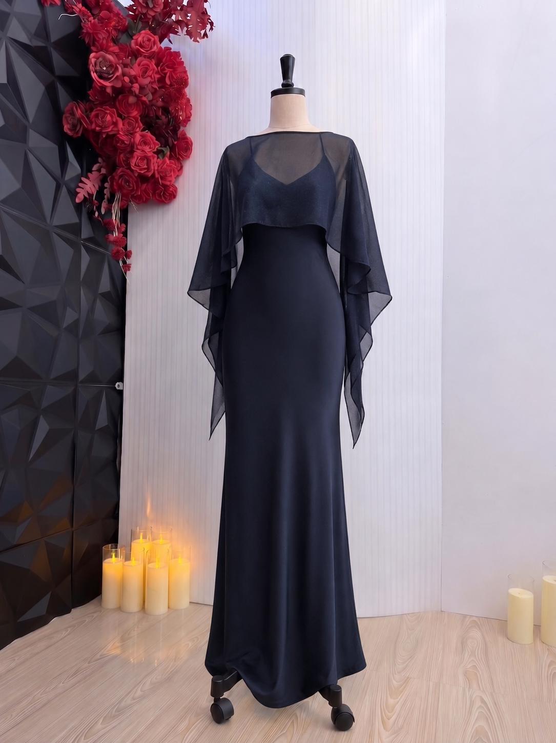 May include: A floor-length, dark navy blue gown featuring a sleeveless bodice with a sweetheart neckline and a sheer, flowing chiffon cape overlay that drapes over the shoulders and arms, creating a dramatic silhouette on a dress form.