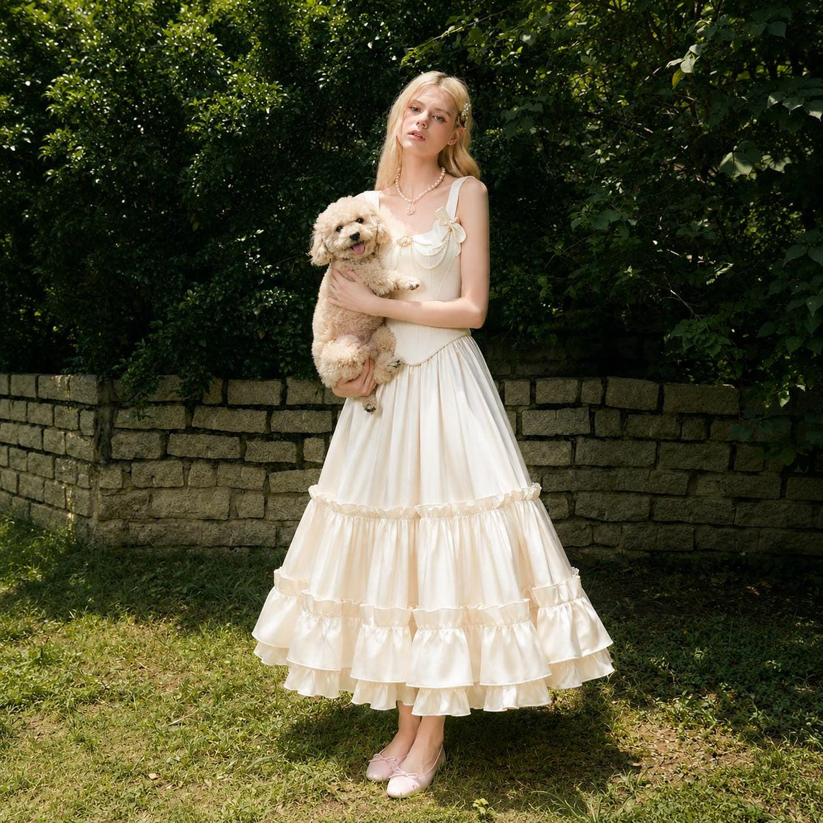May include: A cream-colored sleeveless midi dress featuring a fitted bodice with a sweetheart neckline and a multi-tiered skirt with ruffled hem details. The dress is constructed with a smooth fabric and includes a small bow accent on the chest.