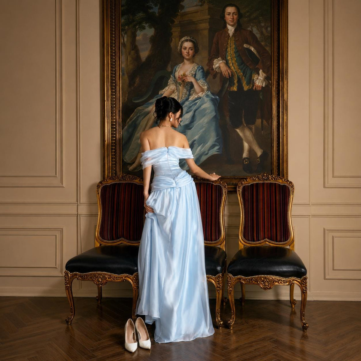 May include: A floor-length, light blue off-the-shoulder gown with a ruched bodice and a flowing skirt. The dress features sheer, draped sleeves that sit off the shoulders, a fitted waistline, and a smooth, satin-like fabric finish.
