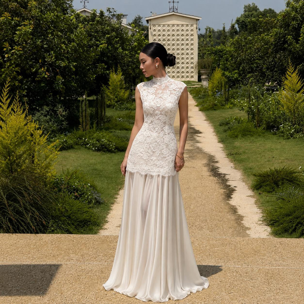 May include: A floor-length sleeveless dress featuring a white lace bodice with a high neckline and a solid white skirt. The lace overlay extends from the neck to the waist, transitioning into a flowing, opaque fabric that reaches the ground.